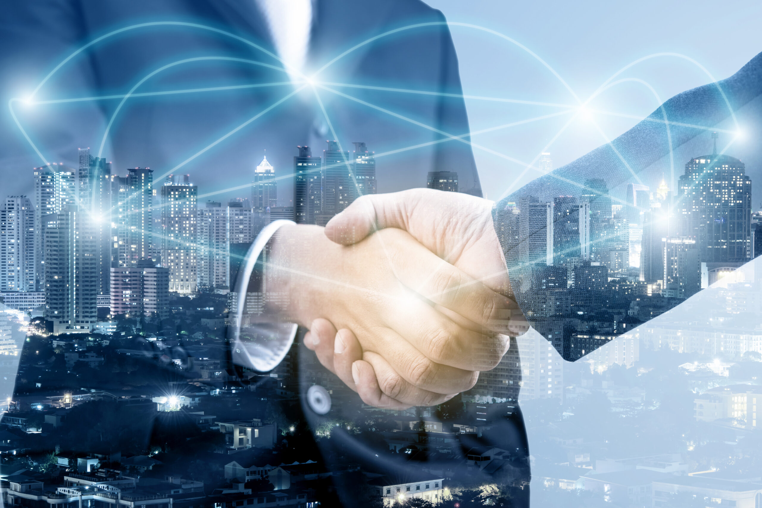 Business professionals shaking hands against a backdrop of a city skyline, symbolizing partnership and collaboration